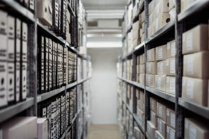 Home Vloermarkeringen in een magazijn met gele lijnen die looproutes, rijpaden en opslagzones aangeven voor duidelijke structuur.